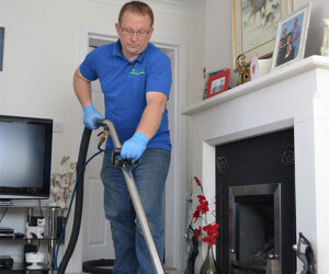 David Roberts in the process of cleaning a carpet rug